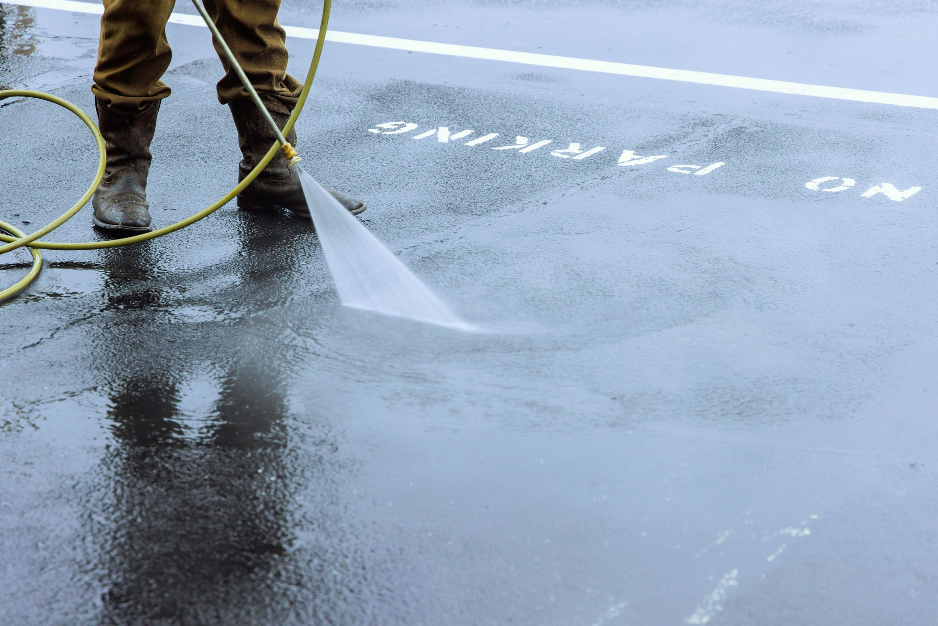 Street is sprayed with pressurized water to be cleaned, a road is washed by water